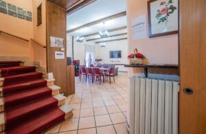 Saletta relax della Dimora Fresilia con scala interna, tavolo centrale e atmosfera raccolta nel borgo di Opi