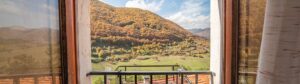 Panorama montano hotel Opi con valle verde, borgo ai piedi delle montagne e vista aperta sul Parco d’Abruzzo