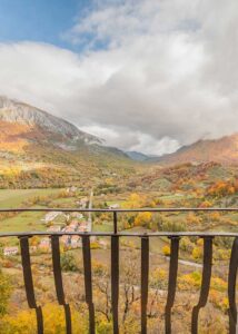 Vista panoramica da dimora storica Opi con balcone in ferro, valle d’autunno e montagne del Parco d’Abruzzo